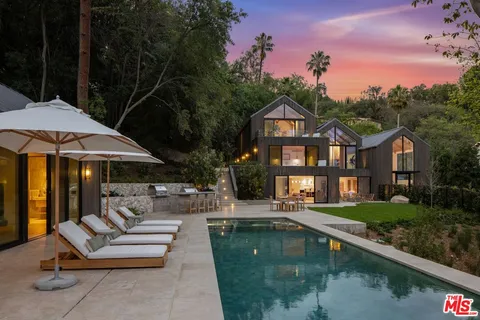 a view of a house with swimming pool and sitting area