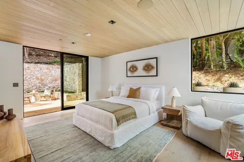 a bedroom with furniture and a large window