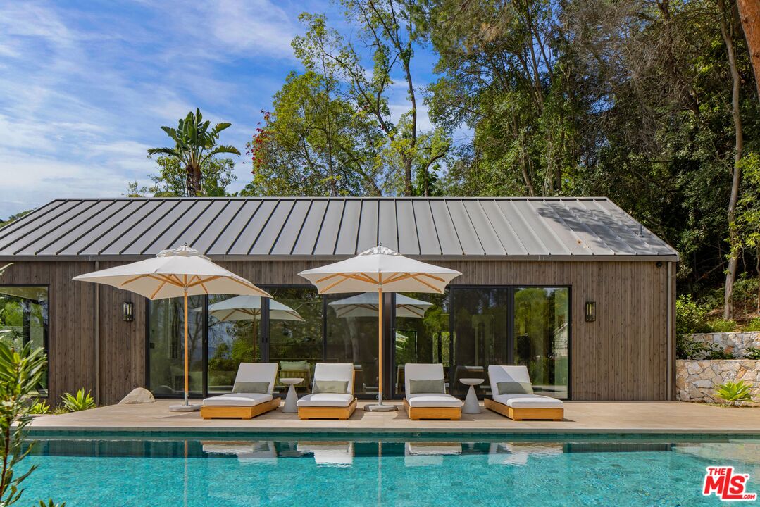 12309 Viewcrest Road Studio City, CA 91604 - Photo 40 of 49 a view of patio with a table and chairs under an umbrella with wooden fence