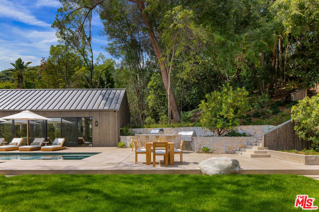 12309 Viewcrest Road Studio City, CA 91604 - Photo 47 of 49 a view of a patio with table and chairs potted plants and large tree