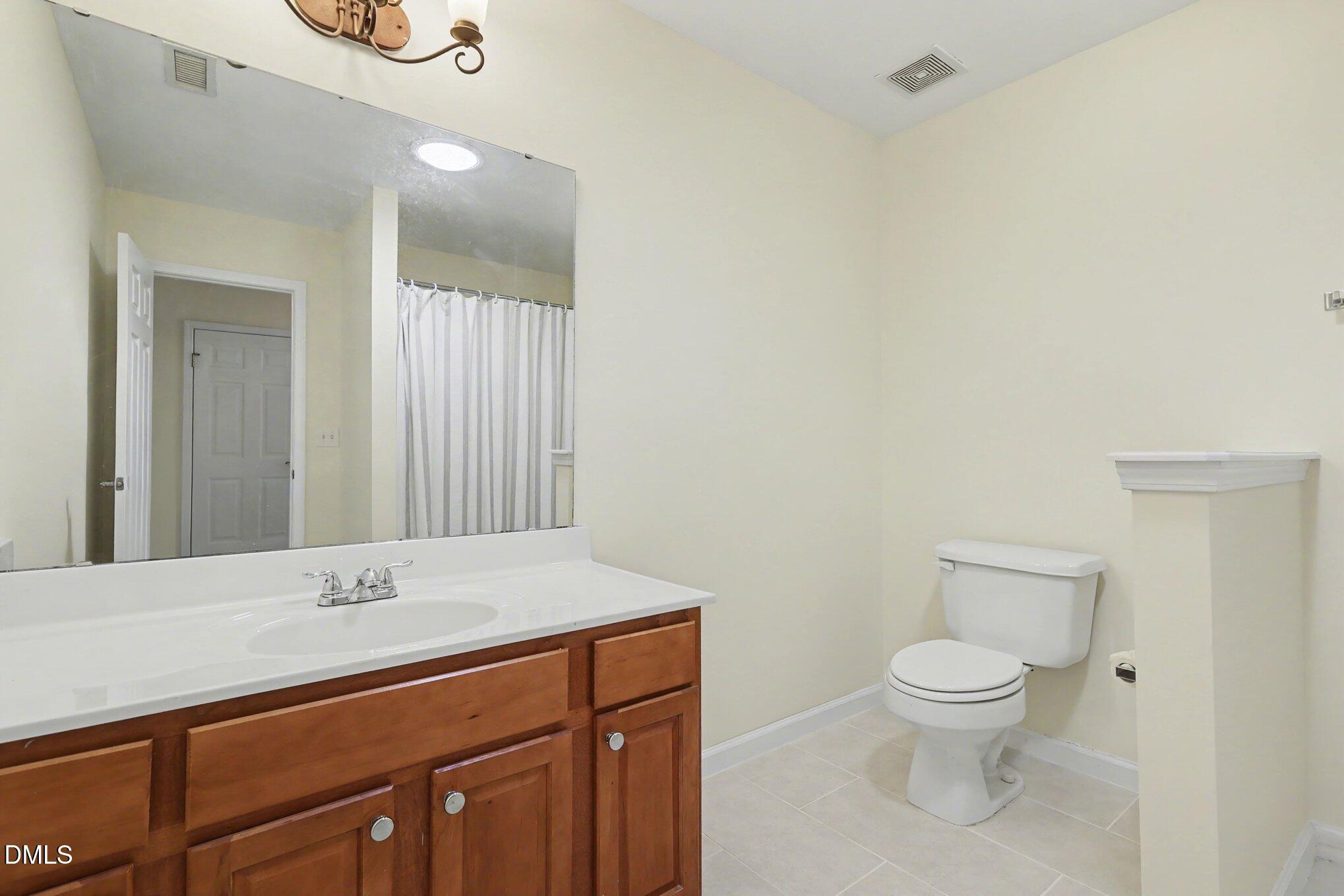 133 Jennel Way Durham, NC 27707 - Photo 25 of 28 a bathroom with a toilet sink and mirror