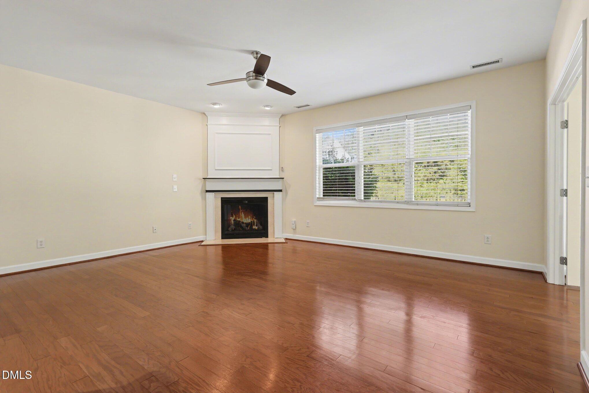 133 Jennel Way Durham, NC 27707 - Photo 4 of 28 an empty room with wooden floor ceiling fan and windows