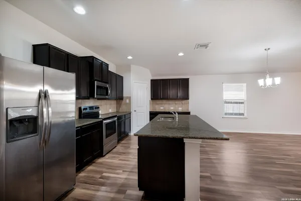 a kitchen with kitchen island granite countertop stainless steel appliances and a sink