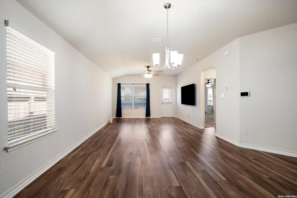 a view of a room with wooden floor fireplace and windows