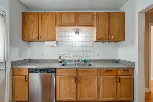 a kitchen with stainless steel appliances granite countertop white cabinets sink and dishwasher