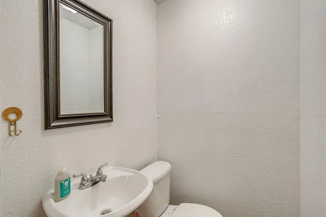 a bathroom with a sink mirror and toilet