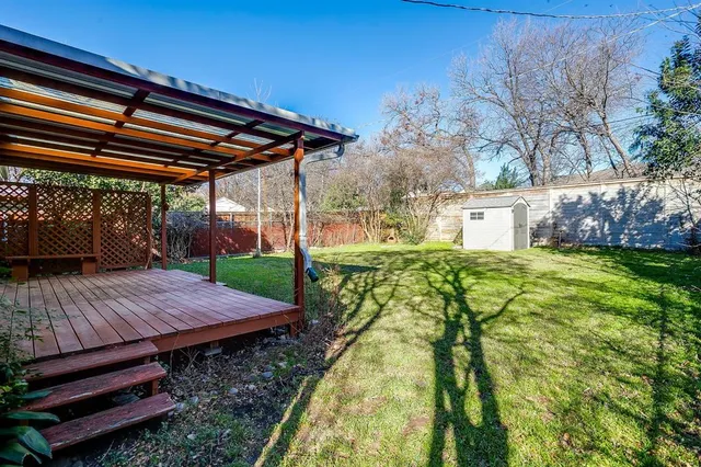 a view of a backyard with table and chairs under an umbrella with a small yard
