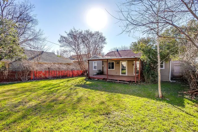 a view of a house with a big yard plants and large trees
