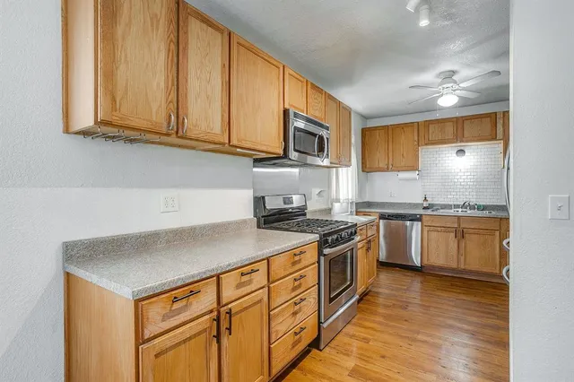 a kitchen with stainless steel appliances granite countertop a stove a sink and a microwave