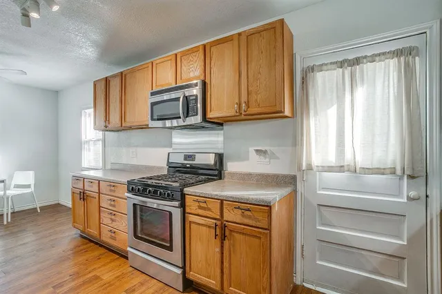 a kitchen with stainless steel appliances granite countertop a stove and a microwave