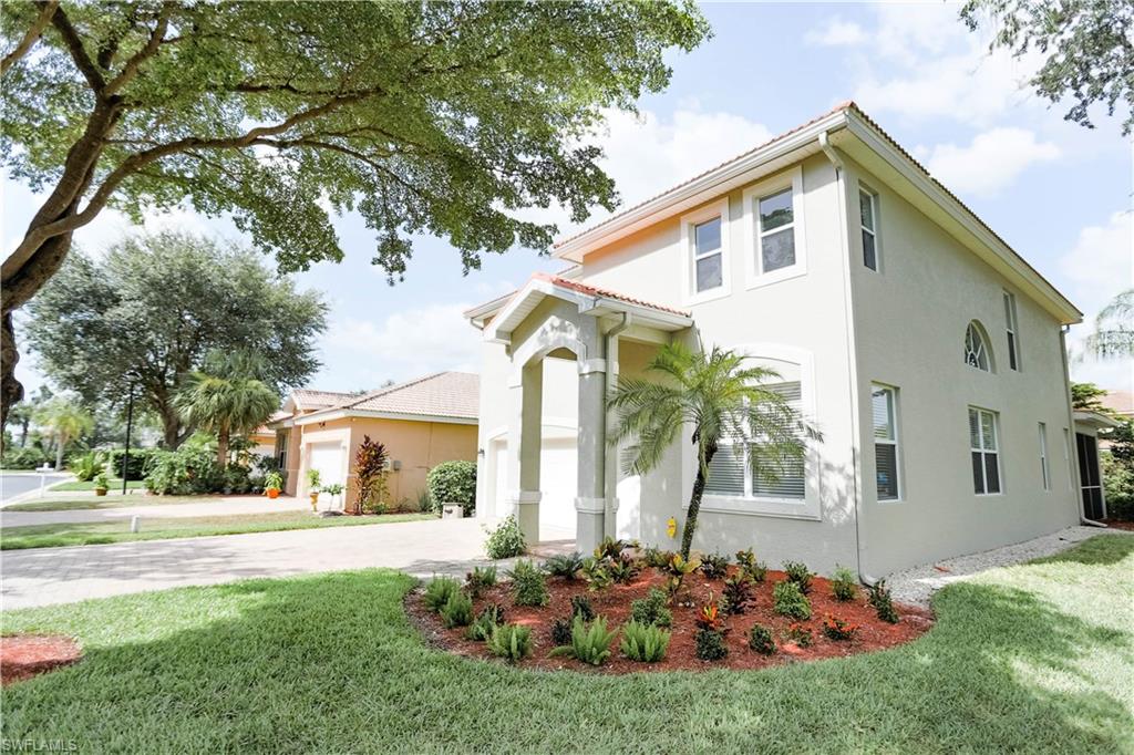 9349 Chestnut Tree Loop Fort Myers, FL 33967 - Photo 1 of 35 a front view of a house with a garden