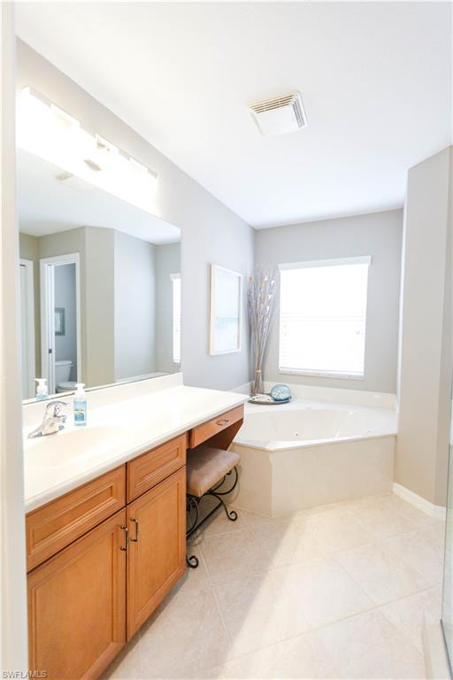 9349 Chestnut Tree Loop Fort Myers, FL 33967 - Photo 21 of 35 a spacious bathroom with a tub sink and mirror