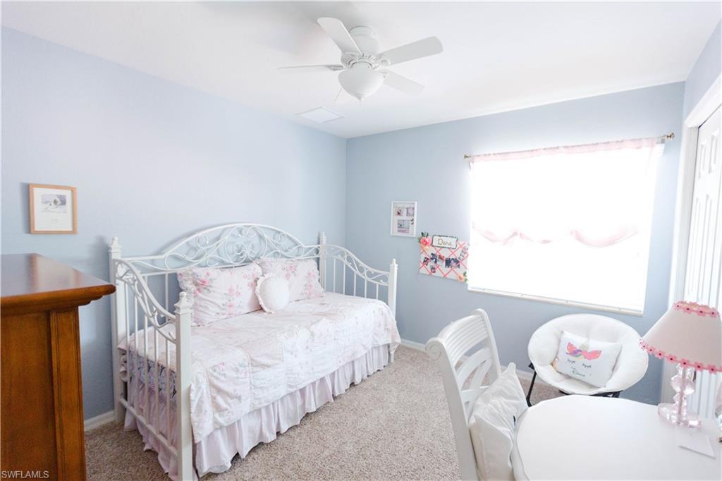 9349 Chestnut Tree Loop Fort Myers, FL 33967 - Photo 28 of 35 a bedroom with a bed and a chandelier