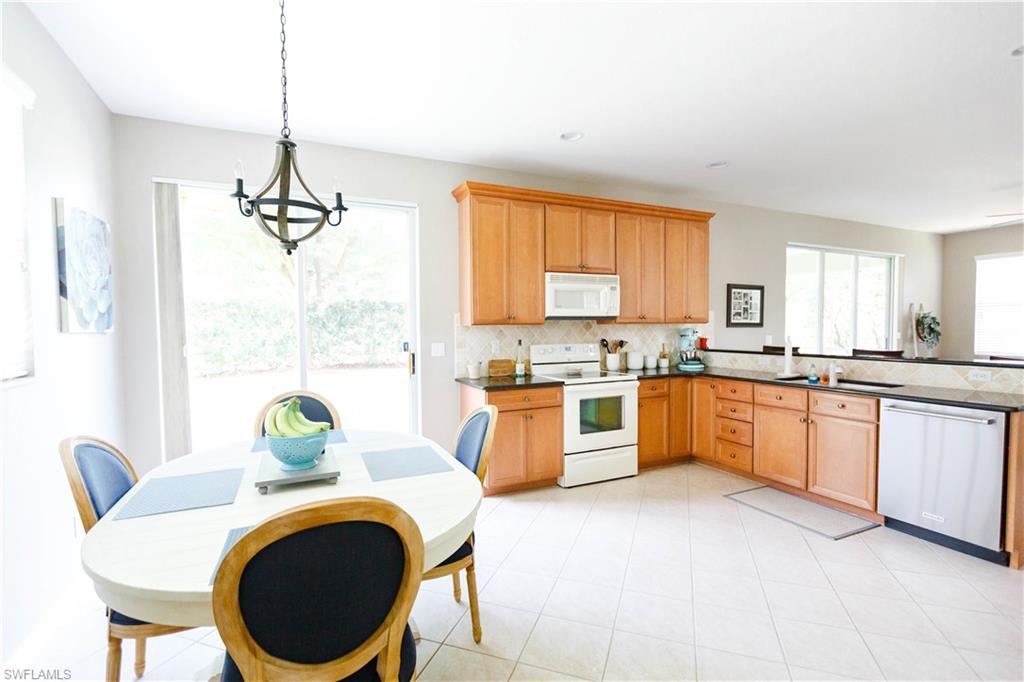9349 Chestnut Tree Loop Fort Myers, FL 33967 - Photo 10 of 35 a large kitchen with granite countertop a stove a sink a window and dining table