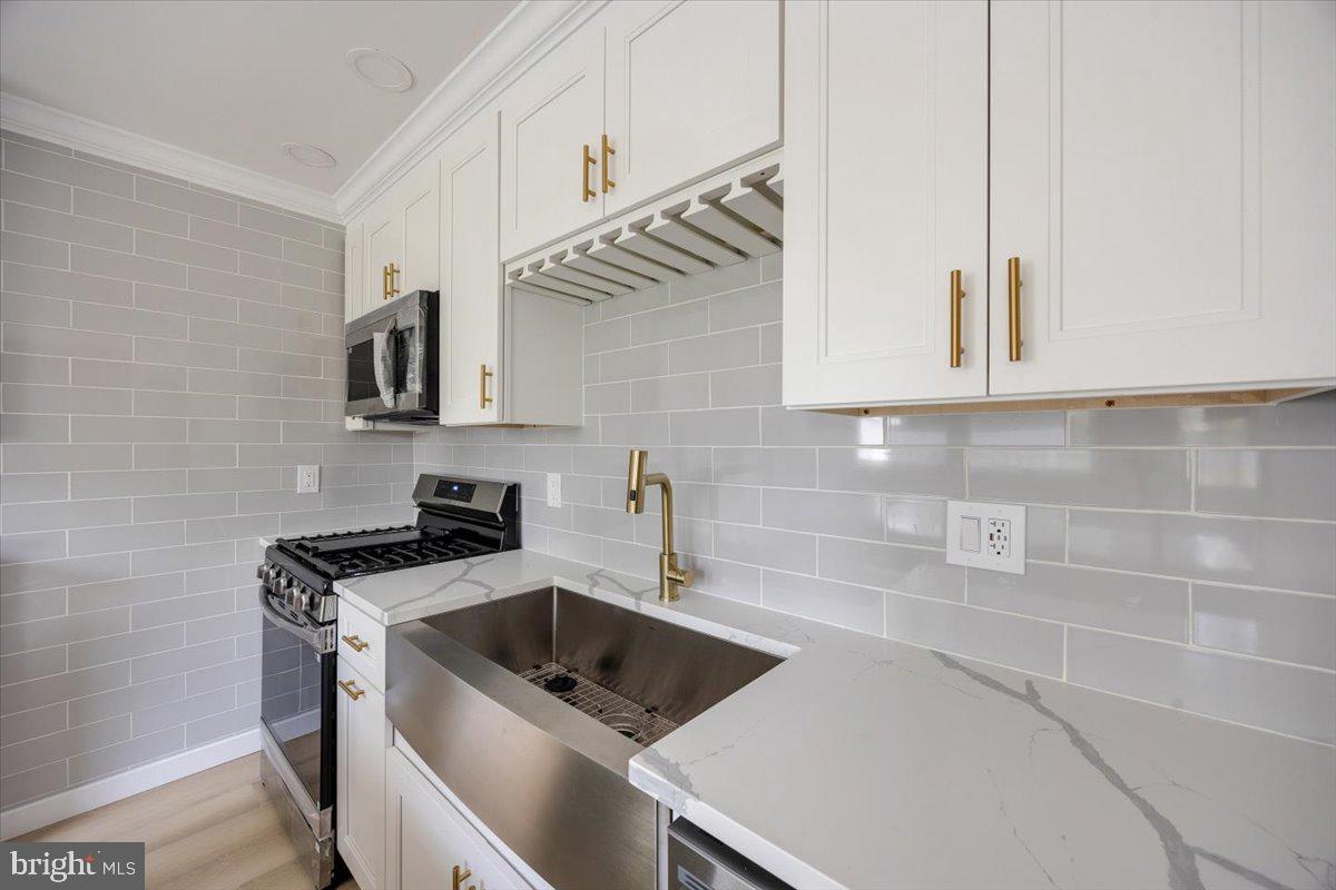 63 Baker Boulevard Marlton, NJ 08053 - Photo 16 of 38 a kitchen with stainless steel appliances a sink a stove and a refrigerator with white cabinets
