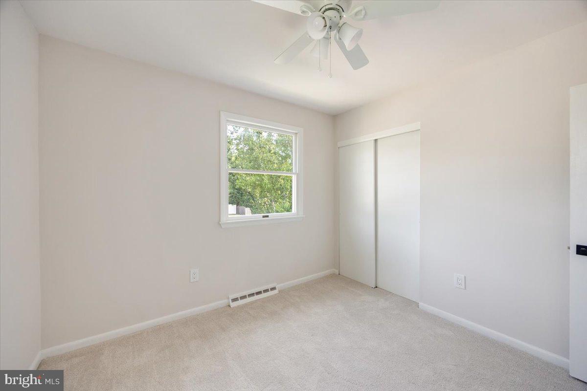 63 Baker Boulevard Marlton, NJ 08053 - Photo 19 of 38 an empty room with a chandelier fan and windows