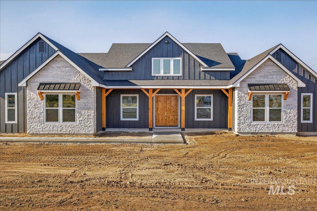 Modern inspired farmhouse featuring covered porch and board and batten siding