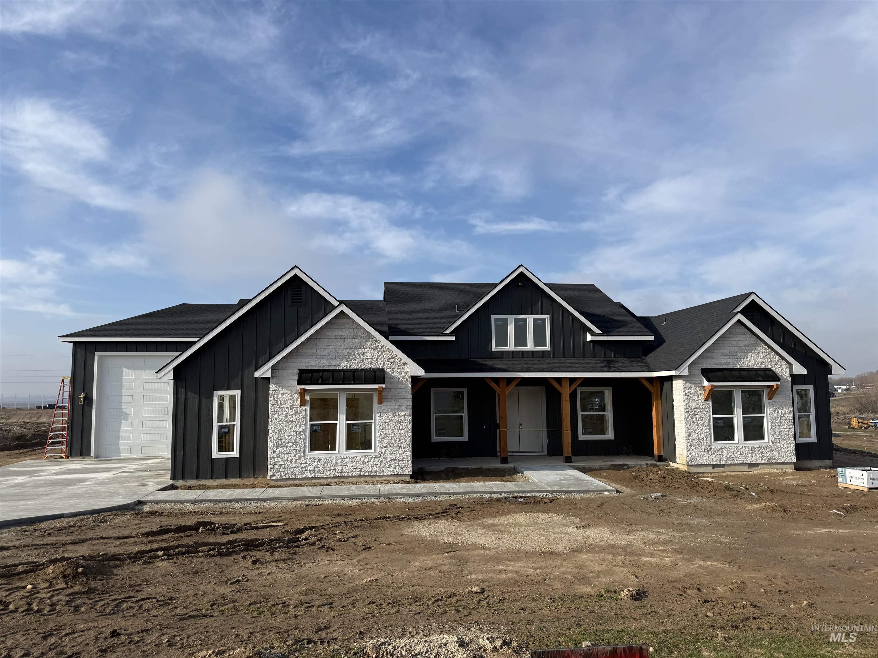23739 Legends Lane Caldwell, ID 83607 - Photo 3 of 9 View of front of home with board and batten siding, a porch, driveway, a shingled roof, and an attached garage