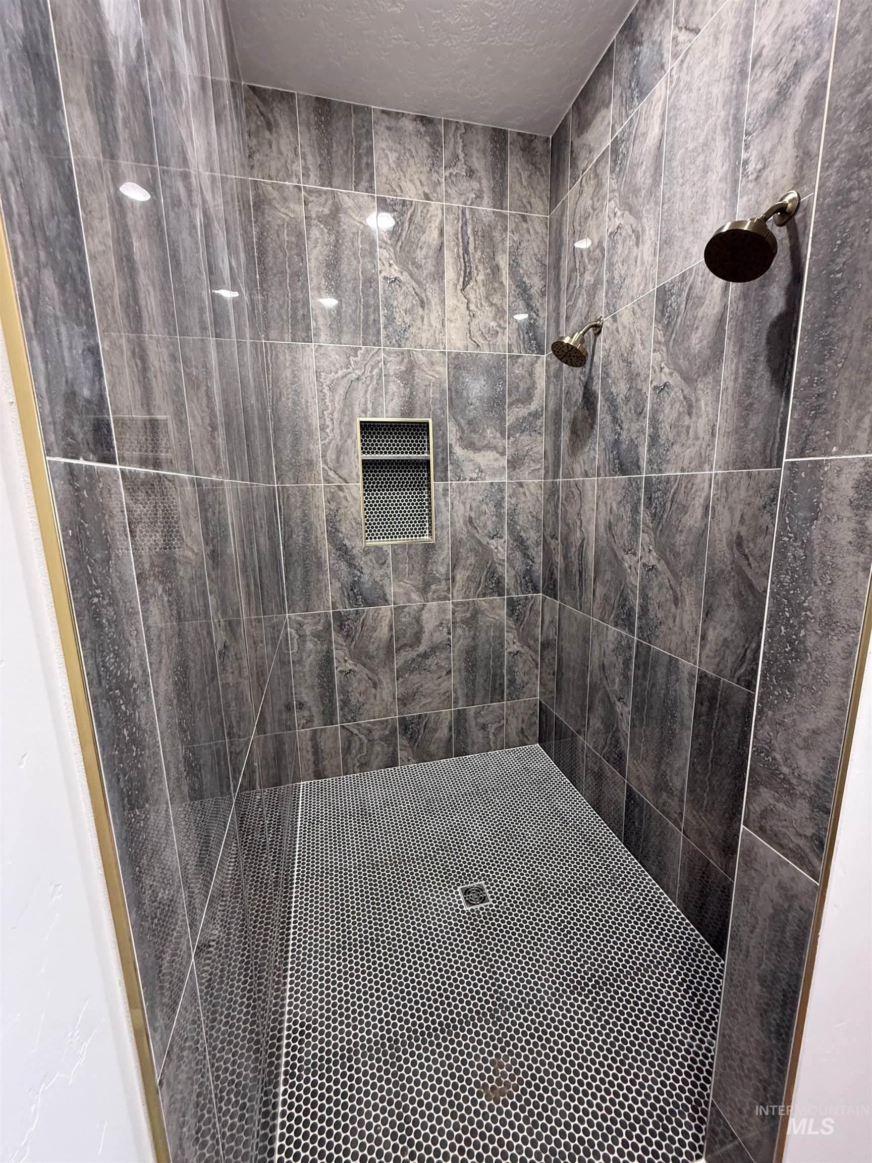 23739 Legends Lane Caldwell, ID 83607 - Photo 7 of 9 Bathroom with tiled shower and a textured ceiling