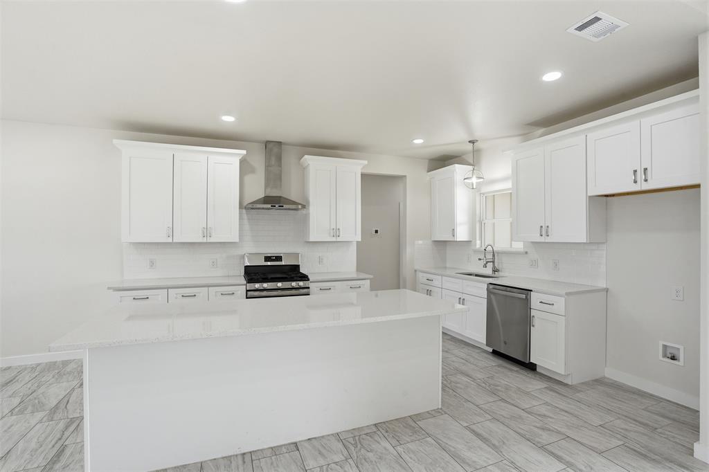 532 Highview Court Godley, TX 76044 - Photo 23 of 39 Bright kitchen featuring an island, white shaker cabinetry, stainless steel appliances, a subway tile backsplash, and light wood-finish flooring