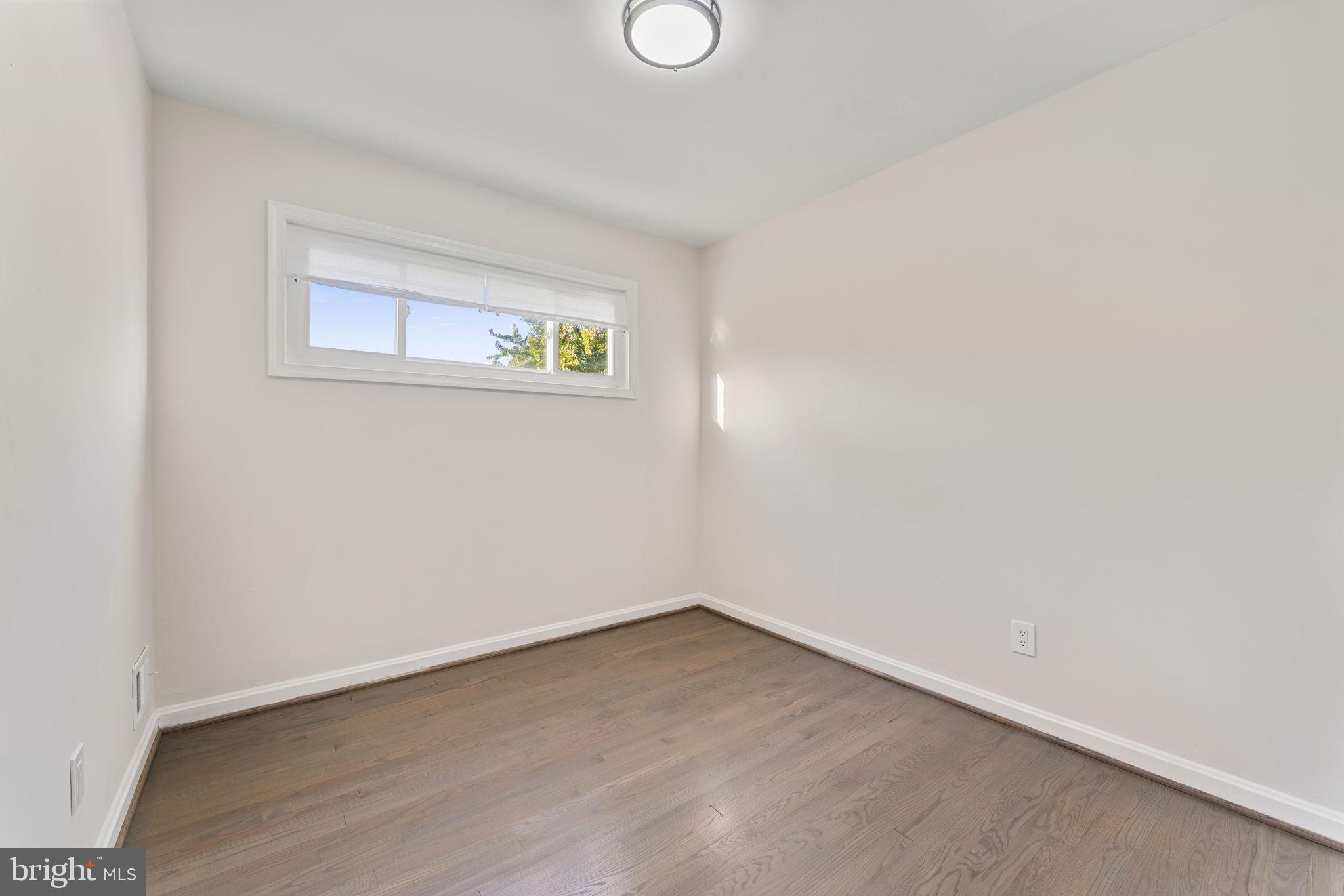 2605 Keith Street Temple Hills, MD 20748 - Photo 16 of 20 a view of an empty room with wooden floor and windows