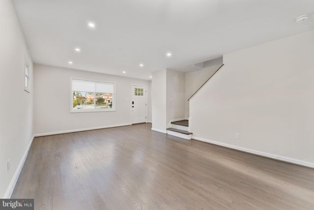 an empty room with wooden floor and window