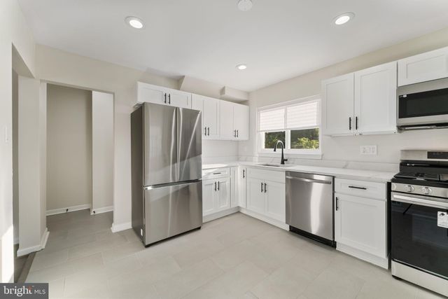 a kitchen with stainless steel appliances a refrigerator sink and stove top oven