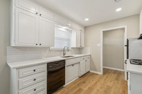 a kitchen with a sink cabinets stainless steel appliances and a window