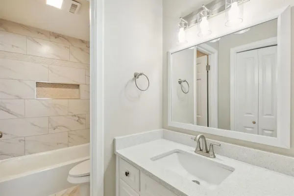 a bathroom with a sink a toilet and shower
