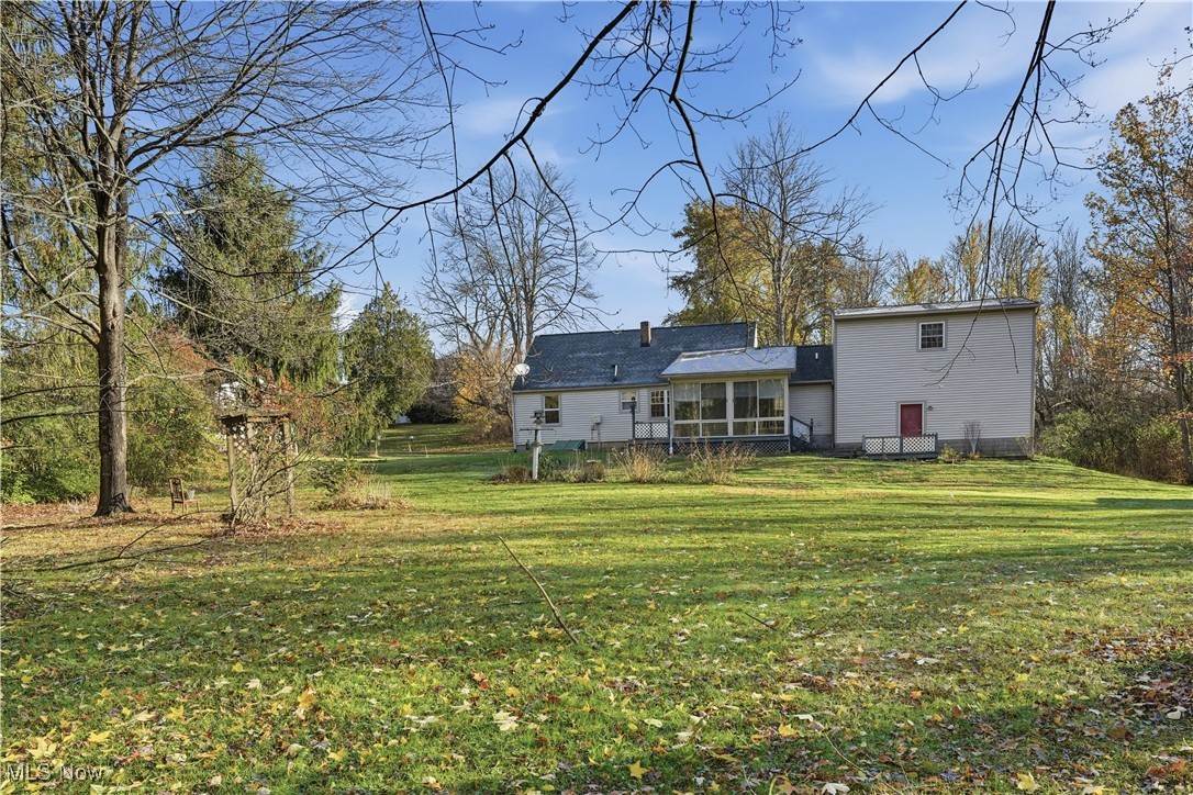 3275 Ranfield Road Kent, OH 44240 - Photo 7 of 33 Rear view of property featuring a lawn and a sunroom