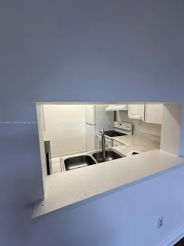a kitchen with a sink and a refrigerator
