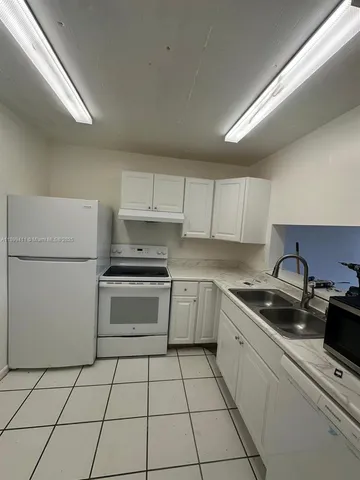 a kitchen with a sink a stove and cabinets