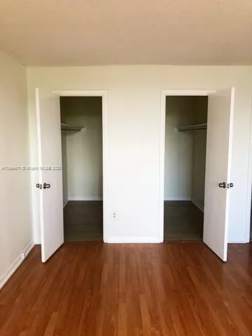 an empty room with wooden floor and closet