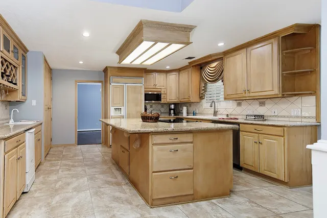 a large kitchen with stainless steel appliances granite countertop a sink and cabinets