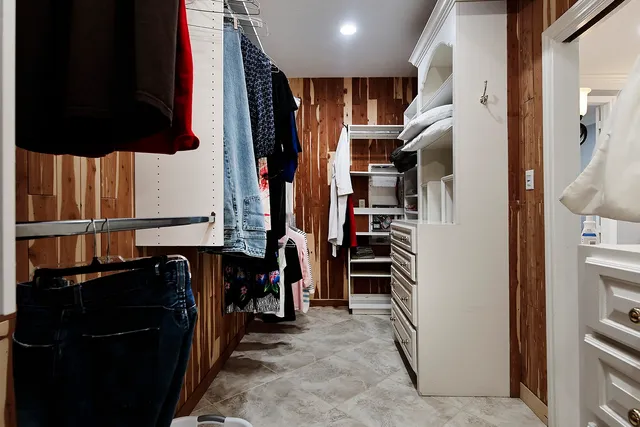 a view of walk in closet with clothes and shoes