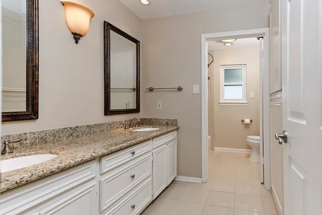 a bathroom with a granite countertop sink and mirror