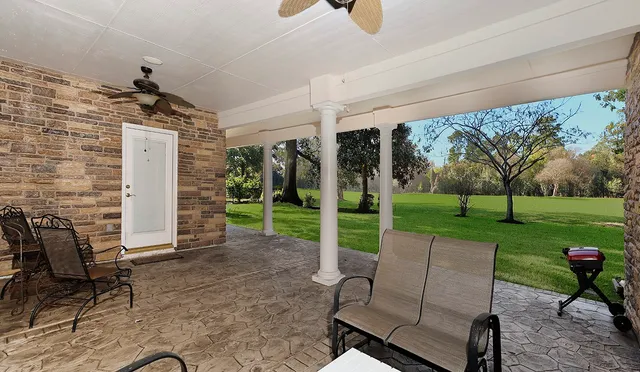 a view of a patio with a table chairs and a yard