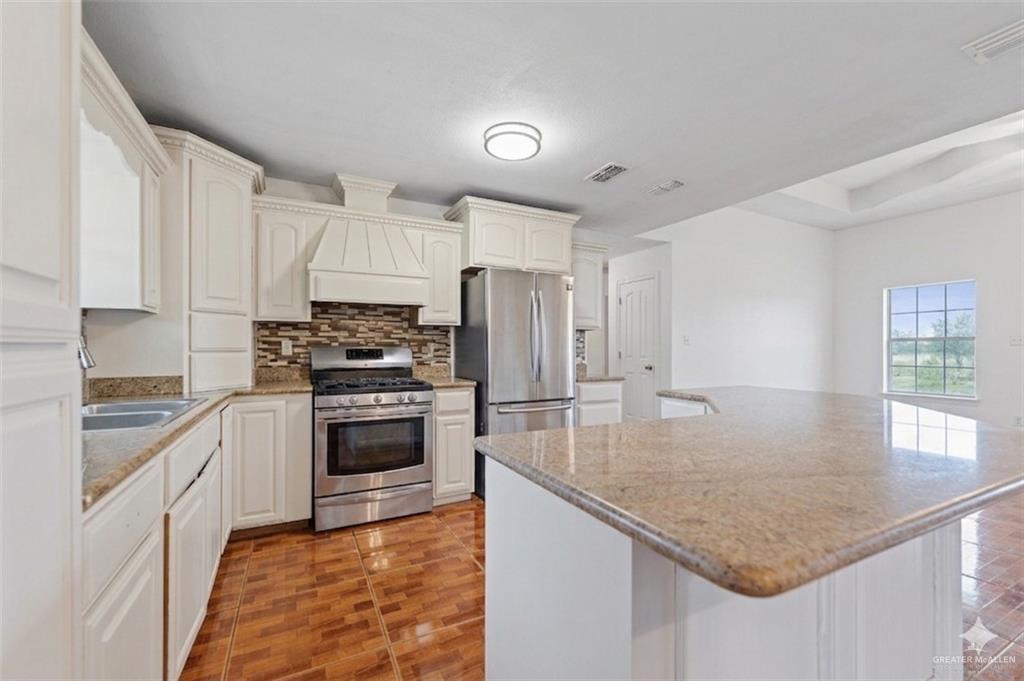 24175 Engleman Road Edcouch, TX 78538 - Photo 13 of 22 a kitchen with kitchen island granite countertop a stove sink and refrigerator