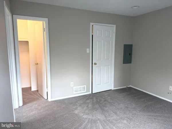an empty room with windows and closet area