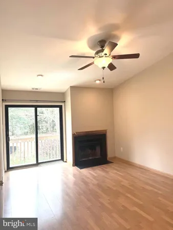 a view of an empty room with a window and a fireplace