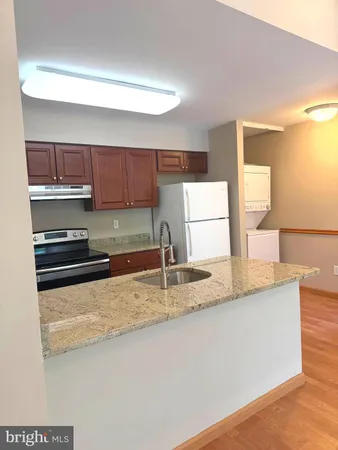 a kitchen with granite countertop a sink and a stove top oven