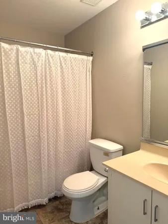 a white toilet sitting next to a shower curtain