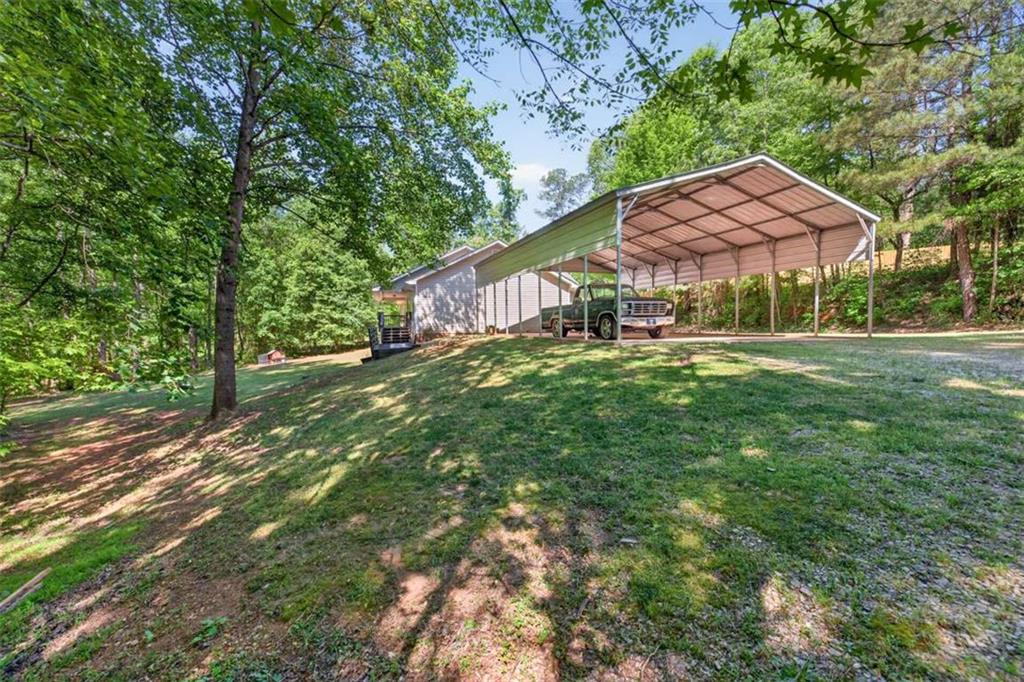 386 Ridgewood Drive Pendergrass, GA 30567 - Photo 4 of 50 a backyard of a house with table and chairs under an umbrella
