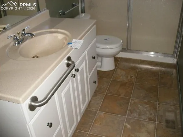 a bathroom with a sink a toilet and shower