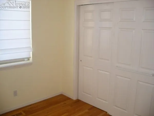 a view of a small space with wooden floor and a window