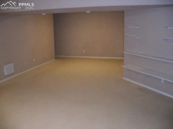 an empty room with a fireplace and windows