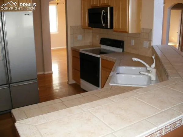 a kitchen with stainless steel appliances kitchen island sink refrigerator and stove