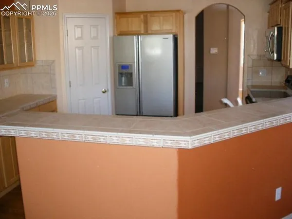 a view of a kitchen with granite countertop a refrigerator and a sink