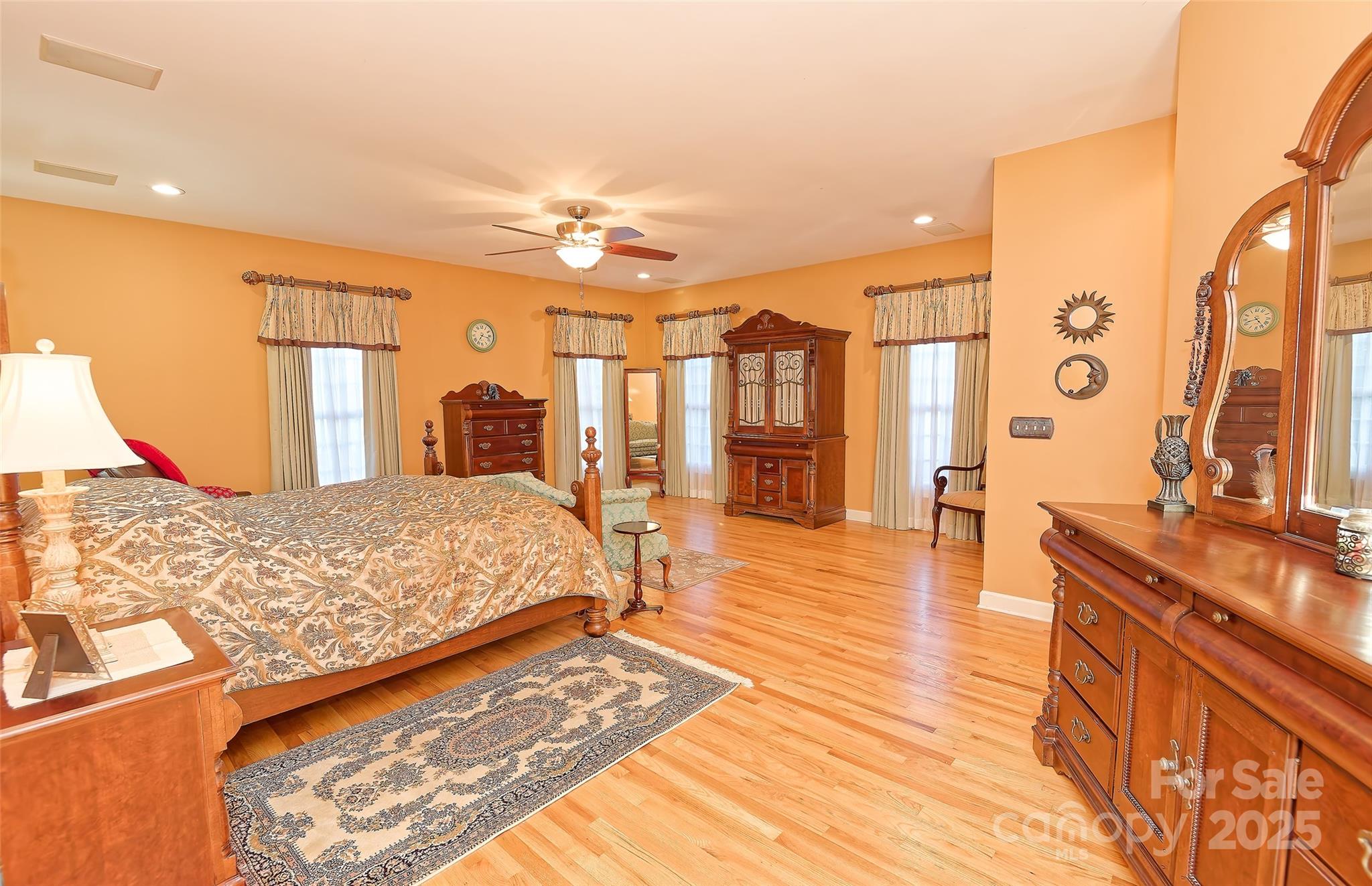 1250 Mountain Creek Road Rutherfordton, NC 28139 - Photo 19 of 48 a spacious bedroom with a large bed and a chandelier