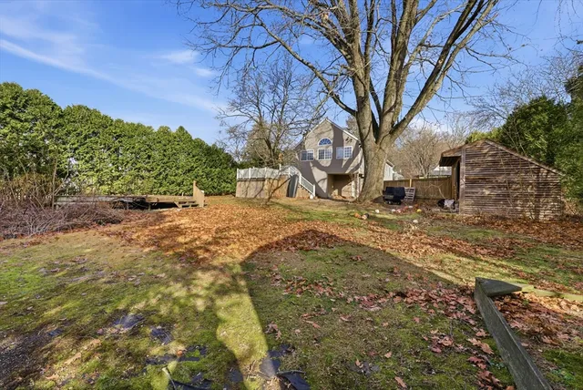 a view of a yard in front of a house with large trees